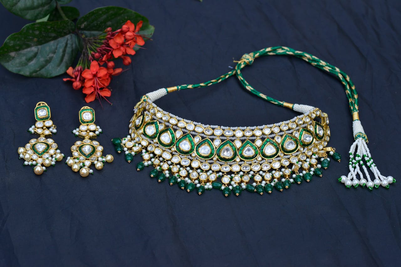 services-02 Elegant necklace and earring set with vibrant flowers on a blue background, perfect for festive attire.