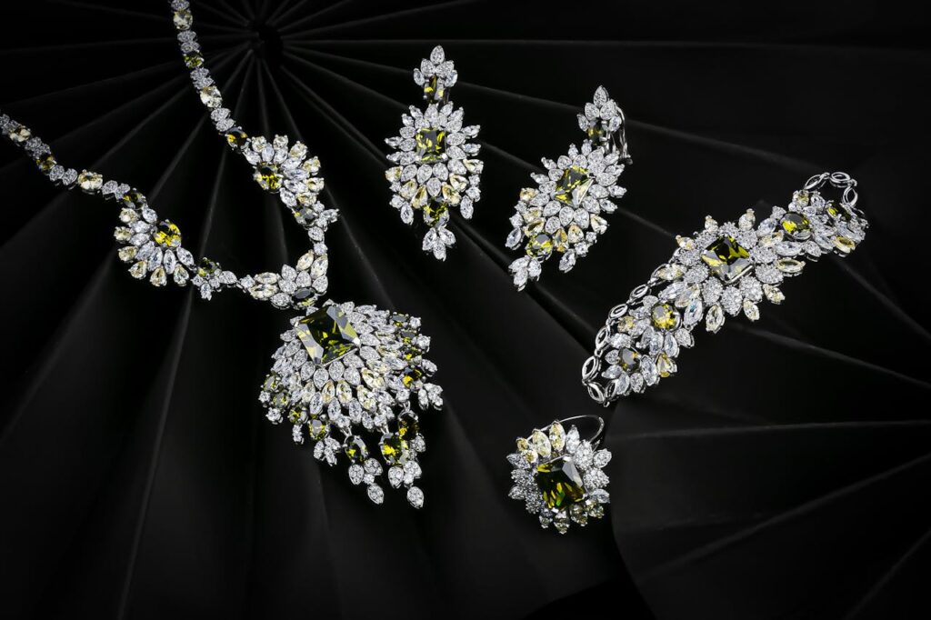 Luxurious set of diamond and emerald jewelry on a black background, highlighting elegance.
