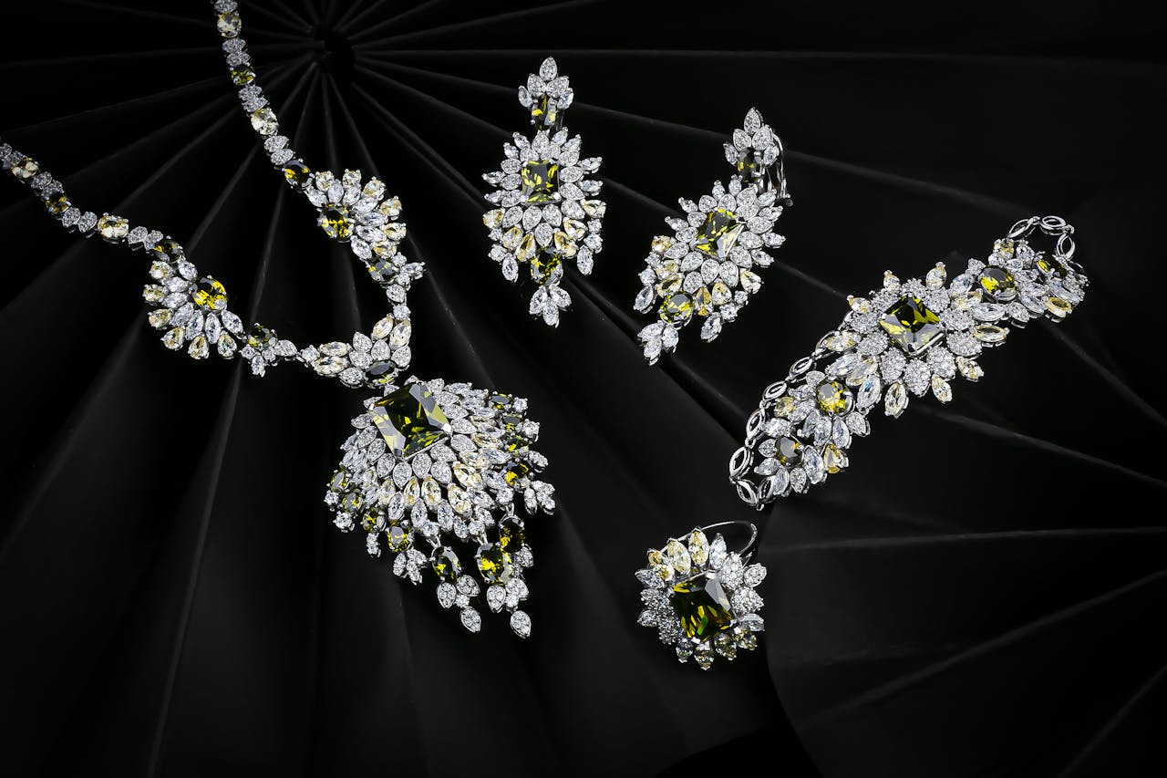Luxurious set of diamond and emerald jewelry on a black background, highlighting elegance.
