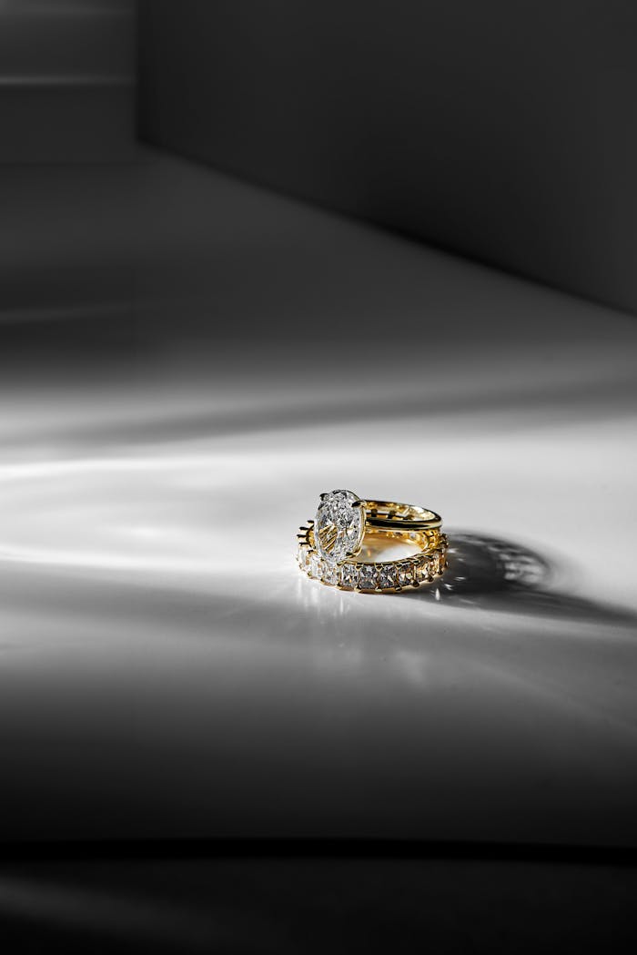 Sophisticated gold and diamond rings showcased in a minimalist light setting for luxury appeal.